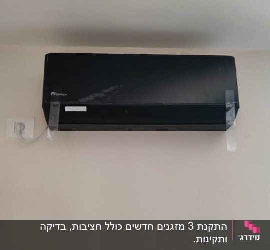מזגן שחור מותקן על קיר עם צינור חשמל